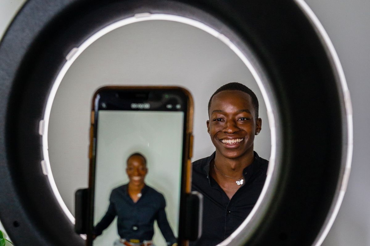 Two comedians filming a skit on a phone with a ring light